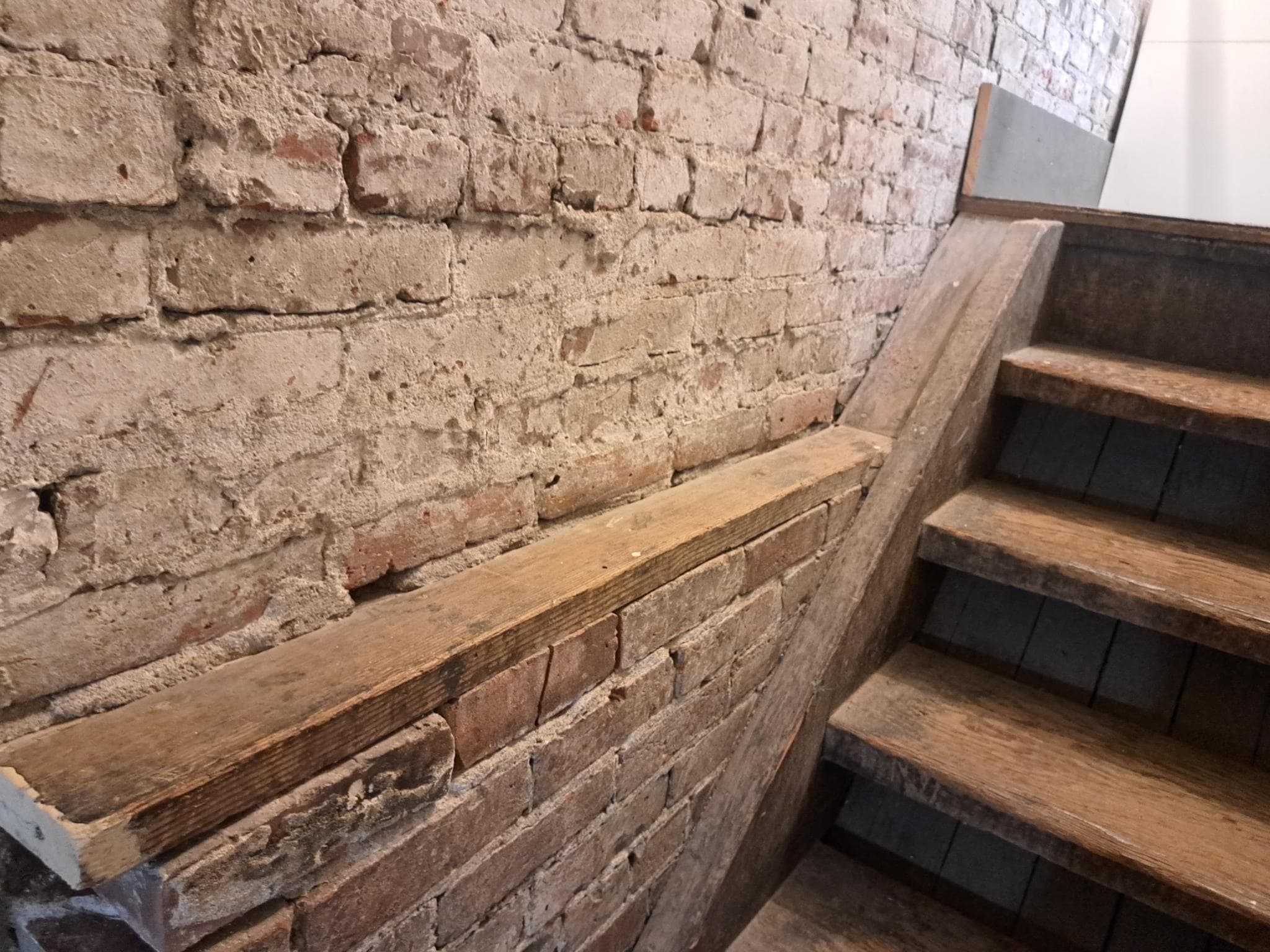 Original exposed-brick wall and reclaimed wood stairs